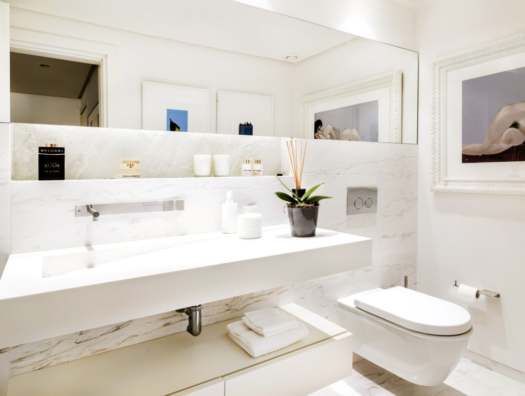 baño blanco con espejo rectangular en disposición horizontal
